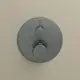 Kreisförmiger Thermostat in Magnetic Grey an einer beigefarbenen Wand. Das Produkt von Ideal Standard zeigt Bedienelemente zur Temperaturregulierung.